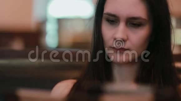 一位年轻漂亮的长发女士在自助餐厅的菜单上仔细看着视频的预览图