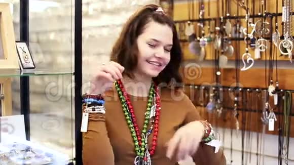 微笑的女售货员在商店里提供时尚的手镯和吊坠视频的预览图