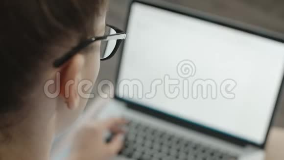 十几岁的学生戴着眼镜用笔记本电脑打字准备考试视频的预览图