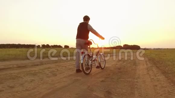 男孩少年骑自行车在大自然的道路上少年儿童骑户外自行车旅行视频的预览图