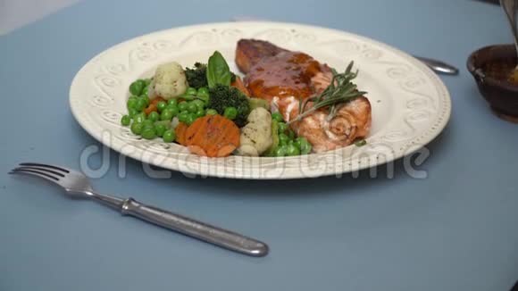 在一盘酱烤猪肉上旁边是一个蔬菜装饰视频的预览图