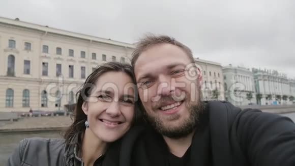 一对幸福微笑的夫妇自拍的视角照片城市里幸福的恋人男人亲吻他的女人慢莫视频的预览图