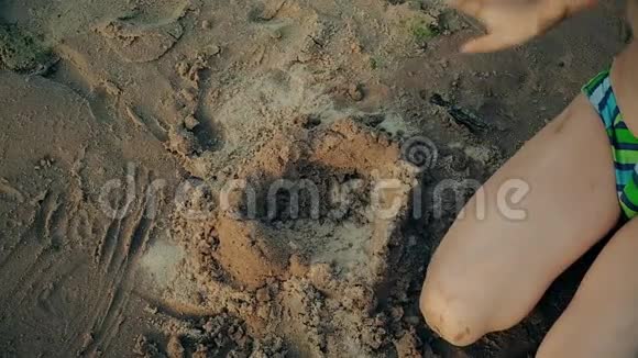 小男孩在沙滩上玩孩子从沙子上雕刻出数字海上夏日活动视频的预览图