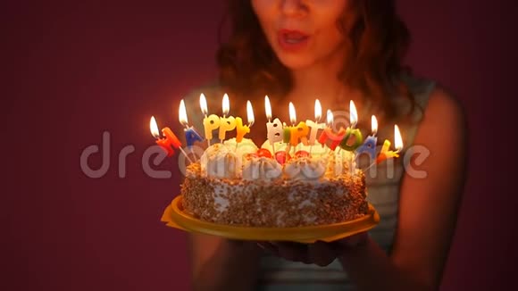 年轻女子在生日蛋糕上吹蜡烛视频的预览图
