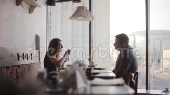 在咖啡馆休息青年男女共餐谈笑风生窗外的城市街景不错视频的预览图