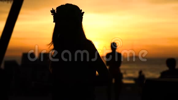夕阳西下快乐的女人在海滩上跳舞背景是大海视频的预览图