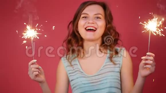 年轻迷人的庆祝女人手里拿着火花跳舞视频的预览图