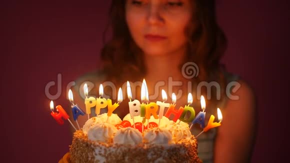 年轻女子在生日蛋糕上吹蜡烛视频的预览图
