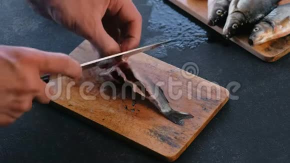 人切鲤鱼的鳍煮鱼双手合拢视频的预览图