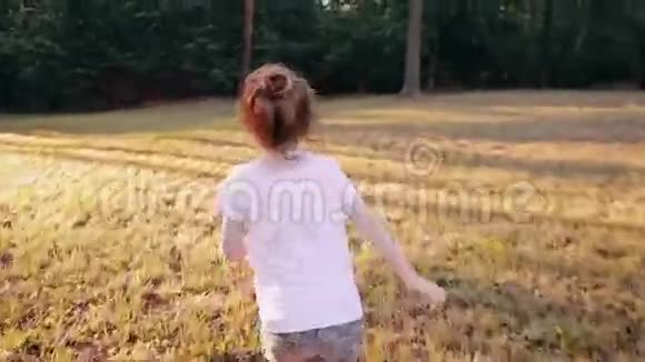 一个快乐的小女孩在一个阳光明媚的夏天从公园里的摄像机跑开后景慢影视频的预览图