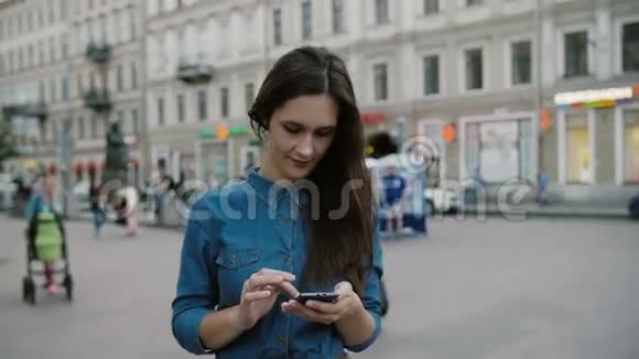 使用智能手机漂亮的年轻女人在一条繁忙的街道上愉快地打电话慢莫稳定射击视频的预览图