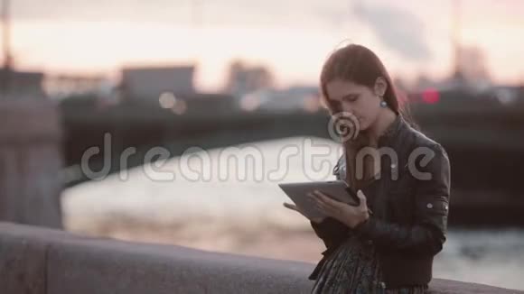 漂亮的年轻女人用平板电脑站在码头的漂亮女士微笑着现代技术视频的预览图