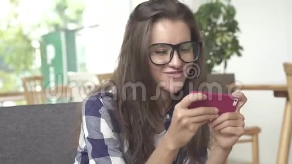 年轻的女商人玩手机游戏视频的预览图