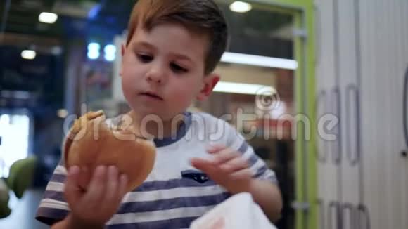 儿童晚餐吃食物男孩午餐吃薯条和汉堡男孩吃汉堡和法式视频的预览图