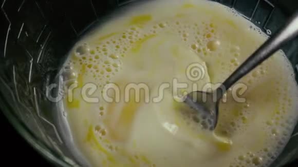 把叉子放在一碗鸡蛋里混合牛奶慢动作视频的预览图