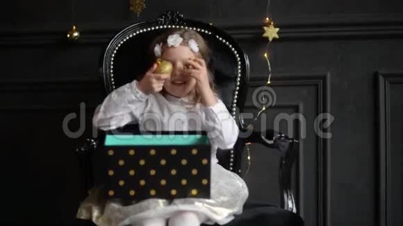 孩子手里拿着圣诞礼物盒美丽的小女孩玩圣诞玩具圣诞快乐新年快乐视频的预览图
