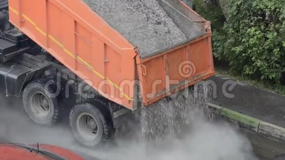 卡车在道路上倾倒沙子和砾石机器在路上倒石头大型工业机器倒灌碎石视频的预览图