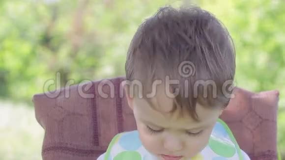 一个坐在儿童桌旁的孩子妈妈给婴儿喂麦片视频的预览图