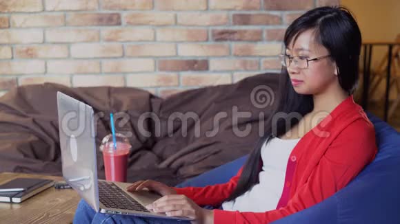 女人在咖啡馆里喝浆果水果冰沙视频的预览图