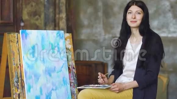 年轻的女艺术家用水彩画和微笑画成相机视频的预览图