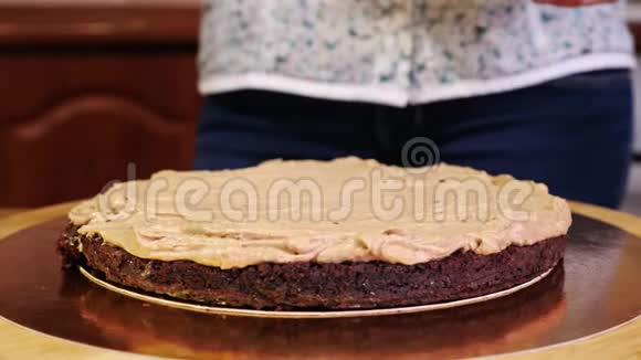 在巧克力海绵蛋糕奶油上倒入坚果的特写视频的预览图