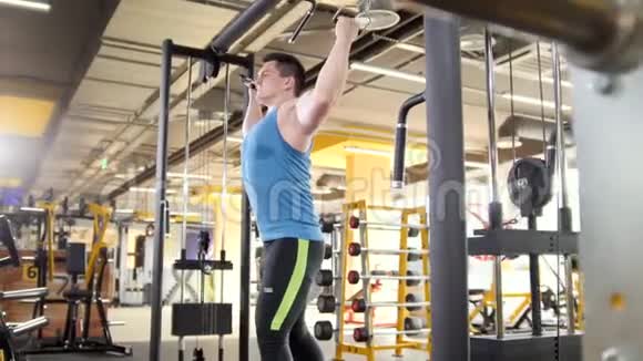 健美运动员在健身房的训练年轻肌肉男进行肱二头肌滑头射击训练视频的预览图