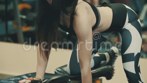 强壮的运动女性在运动健身房中做哑铃运动视频的预览图