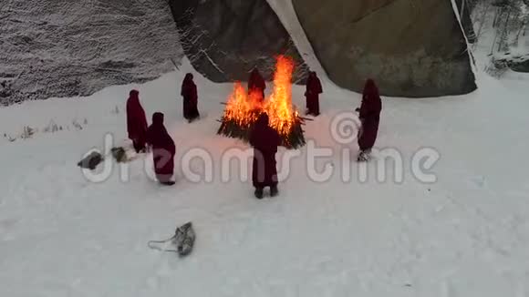 人们呆在篝火旁录像人们晚上呆在火旁一群僧侣在大火附近视频的预览图