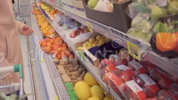 一位女士在一家超市的蔬菜货架上买食品杂货他正在杂货视频的预览图