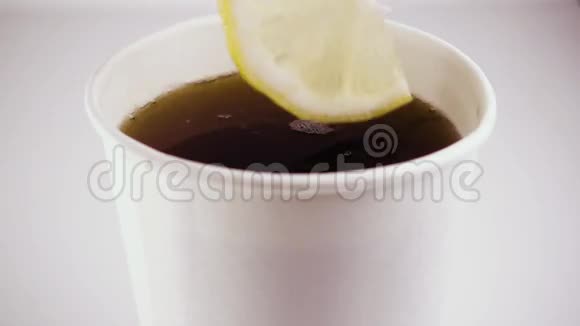 慢动作在有茶的纸板杯里放一个柠檬视频的预览图