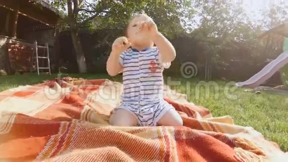 4K视频可爱的小男孩爬在草地上后院视频的预览图