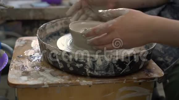 女人和男孩在车间里用陶轮做陶瓷碗视频的预览图