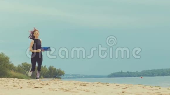 年轻健康的生活方式女人在日出海滩跑步在城市海滩附近的沙滩上奔跑的女孩视频的预览图