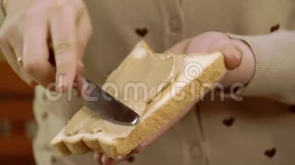 带刀的女孩把花生酱涂在面包上视频的预览图