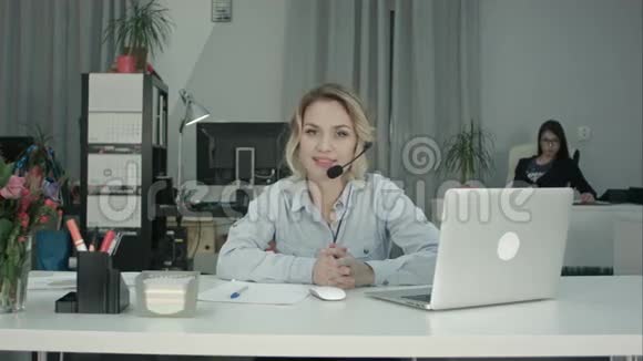 微笑的女顾问提供公司服务的耳机视频的预览图