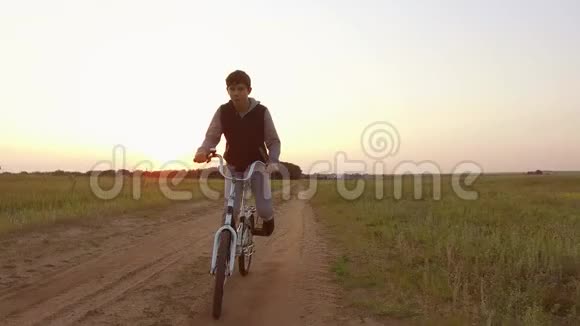 男孩少年骑自行车在大自然的道路上少年骑自行车到户外旅行视频的预览图