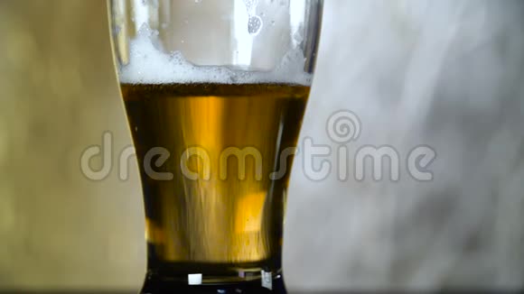 淡啤酒倒在灰色背景的玻璃杯中视频的预览图