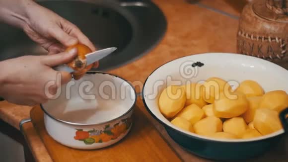 女人手在家厨房里剥土豆慢动作视频的预览图