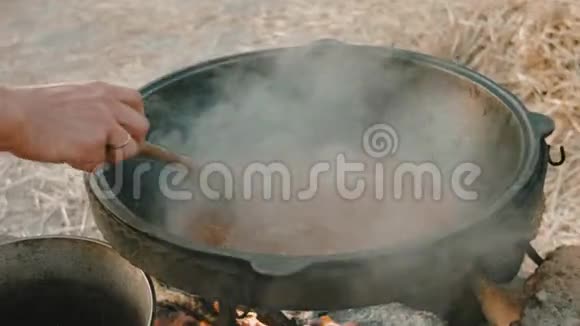 用勺子搅拌汤的手的特写视频的预览图