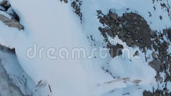 空中观景特写的边缘流动的冰川覆盖着雪和石头高在山上自然破坏视频的预览图