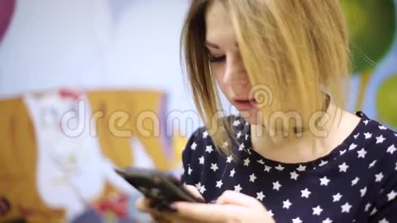 一个亚洲女女孩在一部黑色硅胶外壳中的智能手机上输入文字形状为猫视频的预览图