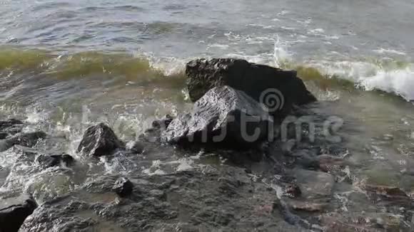 石头和白天海水的缓慢流动视频的预览图