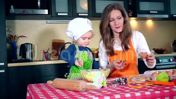 妈妈和女儿在厨房一起做蛋糕时带着鸡蛋视频的预览图