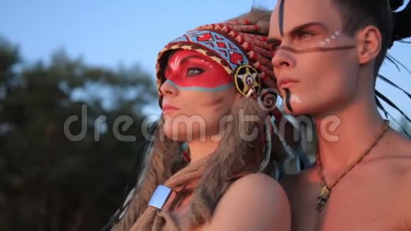 日落时分美丽的美洲印第安人男女穿着传统服装在海边视频的预览图