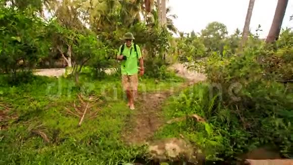 游客老人在公园的植物丛中跳跃视频的预览图