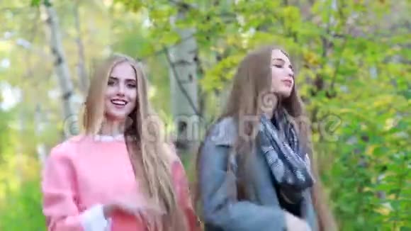 两个留着长发的年轻女孩在秋天的大自然中翩翩起舞视频的预览图