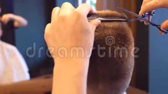理发店用剪刀和梳子剪男客户的头发口渴的过程慢动作关闭视频的预览图