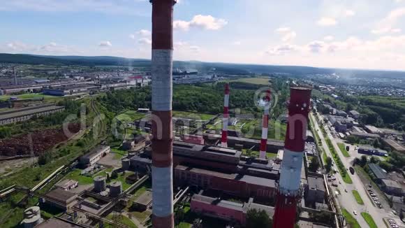 城市景观与工业建筑工厂三个高的红色和白色工业管道在清澈的万里蓝天上视频的预览图