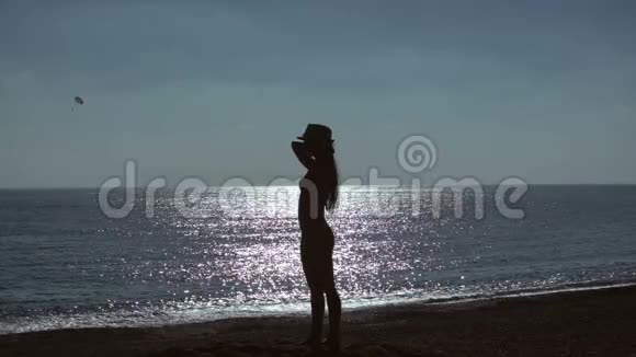 海背景海滩上年轻女子的剪影慢动作视频的预览图