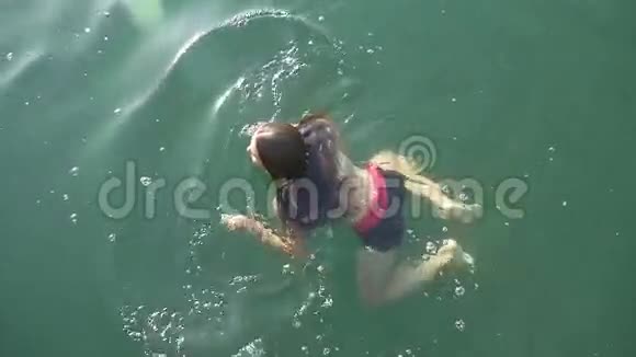 年轻女子在清澈的湖里游泳视频的预览图